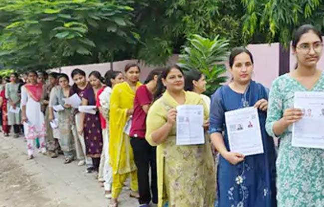 सोनीपत: परीक्षा केंद्र में प्रवेश के लिए लंबी कतार में लगी महिला परीक्षार्थी