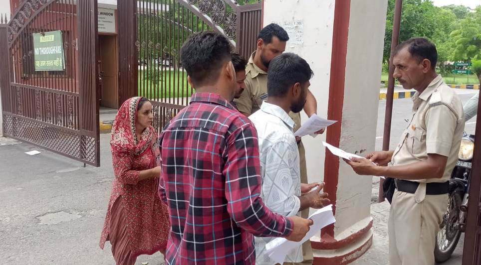 परीक्षार्थियों के दस्तावेज चेक करता पुलिसकर्मी।