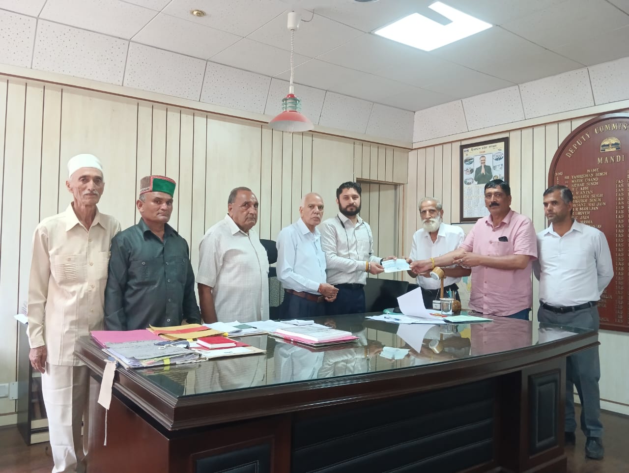उपायुकत काे आपदा राहत के  नौ लाख रूपए साैंपते हुए।