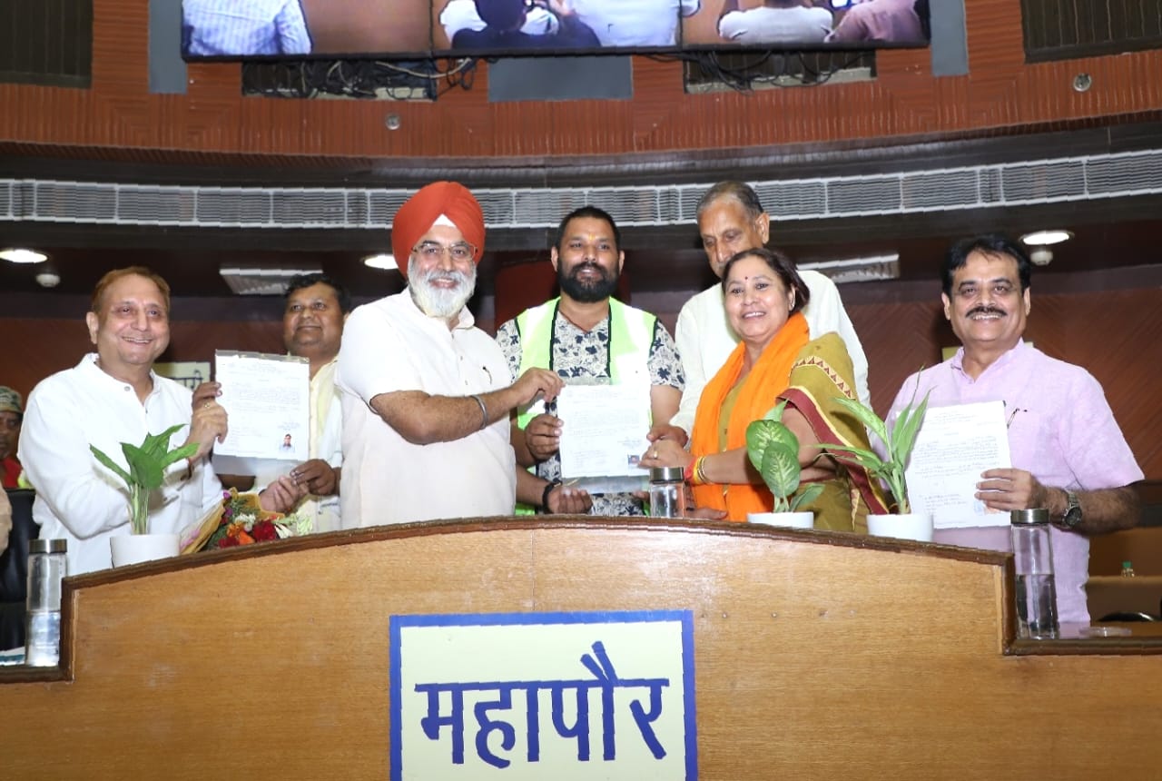 दिल्ली के महापौर राजा इकबाल सिंह, उपमहापौर, अध्यक्ष और नेता सदन सफाई कर्मचारियों को नियमितीकरण पत्र देते हुए