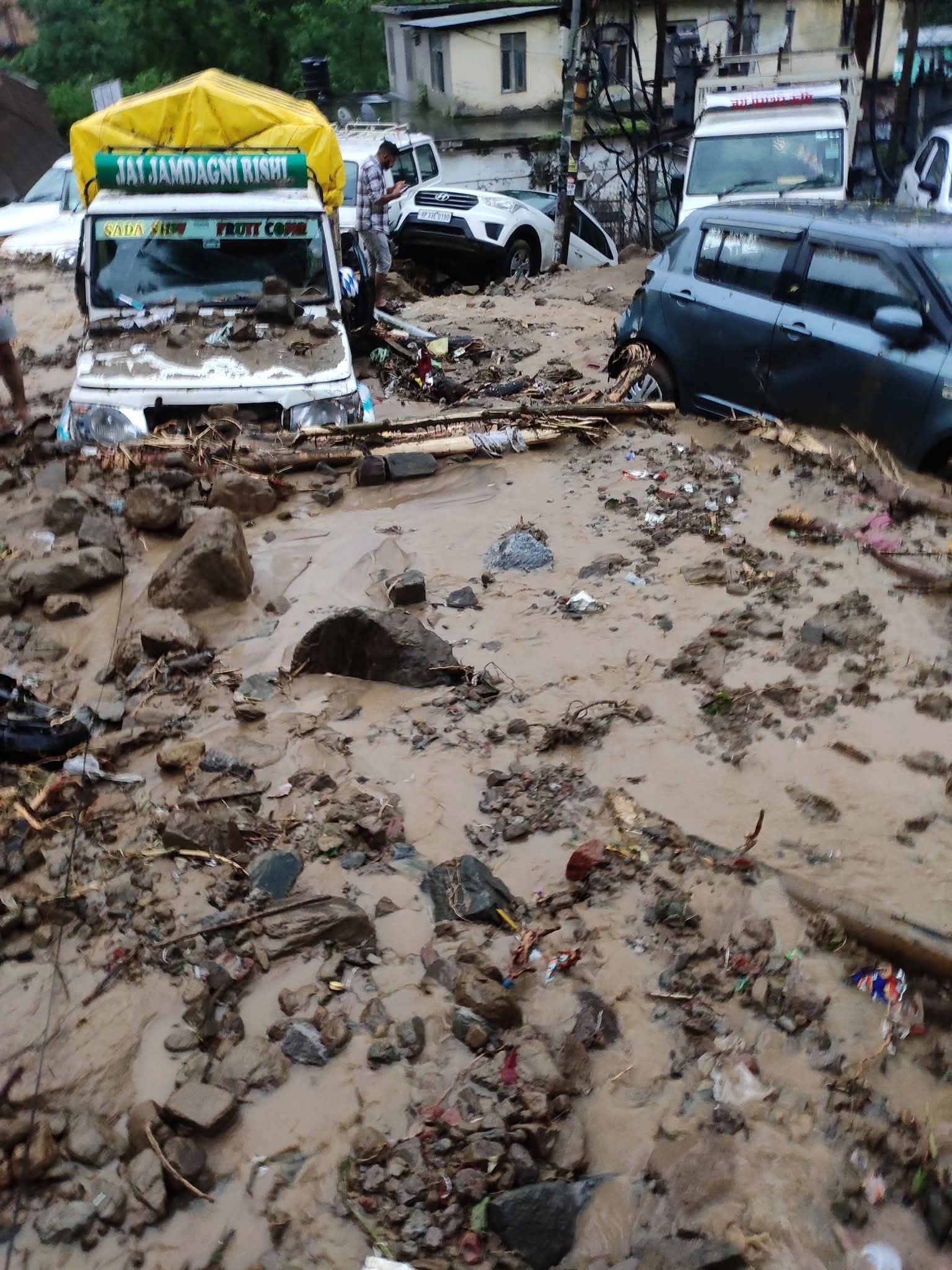 मंडी के जेल रोड़ में आया मलबा और मलबे में दबी गाड़ियां। मंडी के जेल रोड़ में आया मलबा और मलबे में दबी गाड़ियां।