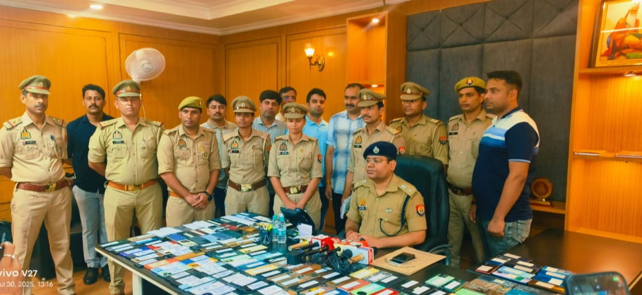 स्वामियों को मोबाइल फोन लौटाते पुलिस अधिकारी