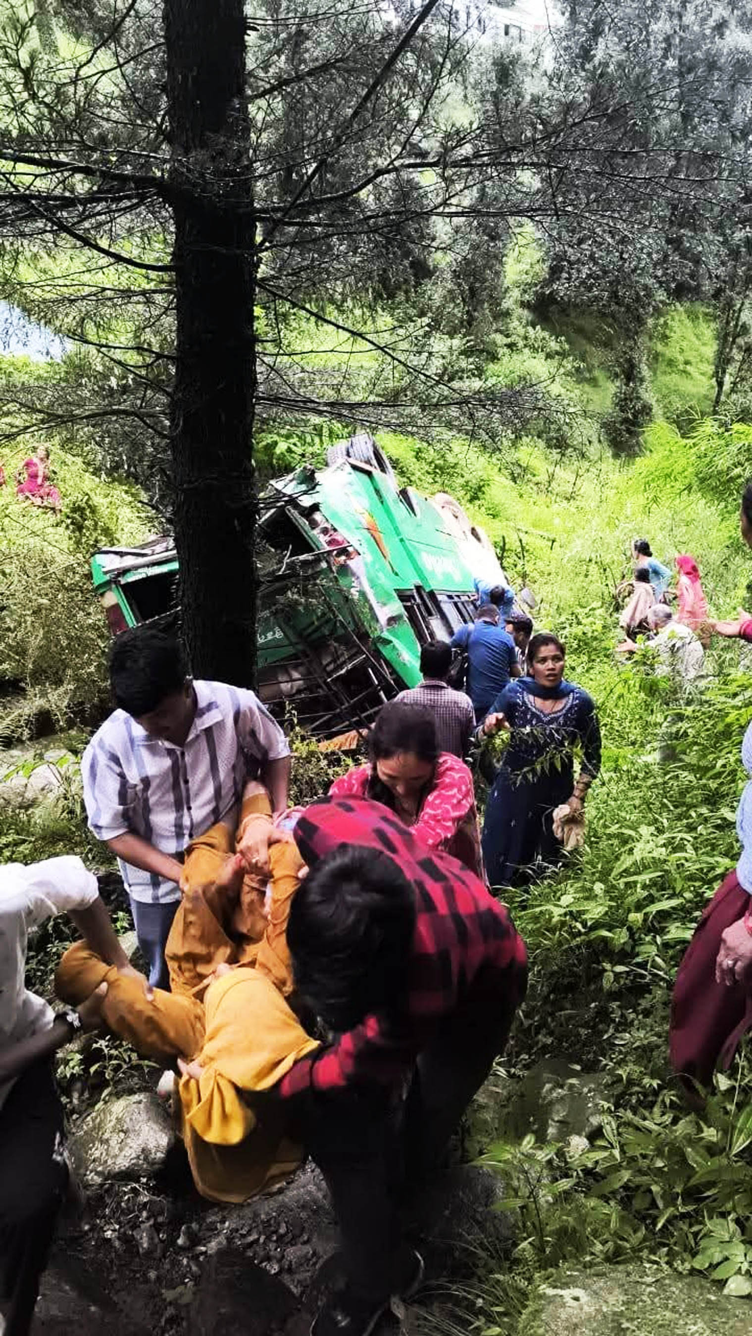 घायलों को सड़क तक लाते हुए लोग