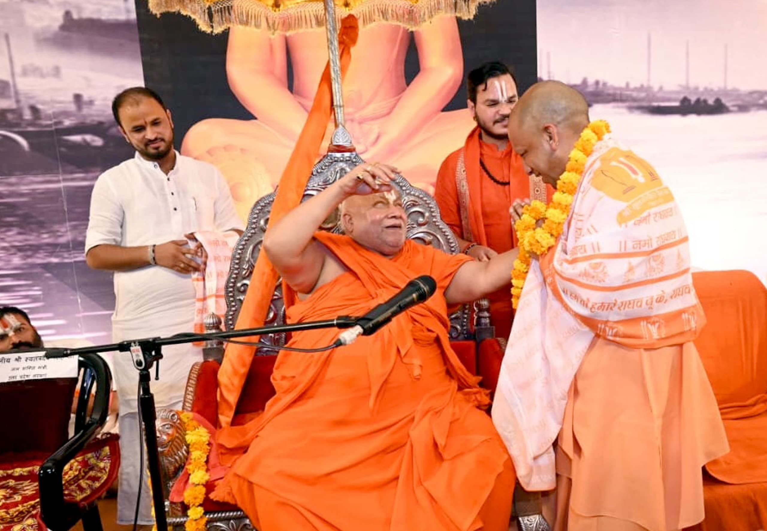 मुख्यमंत्री योगी आदित्यनाथ समारोह में मंचासीन जगतगुरु स्वामी रामभद्राचार्य से बात करते हुए।