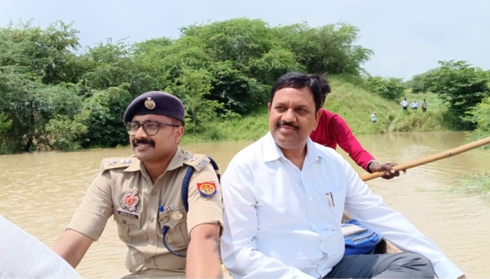 फोटो- बाढ़ इलाके नौका से  निरीक्षण करते डीएम व पुलिस अधीक्षक