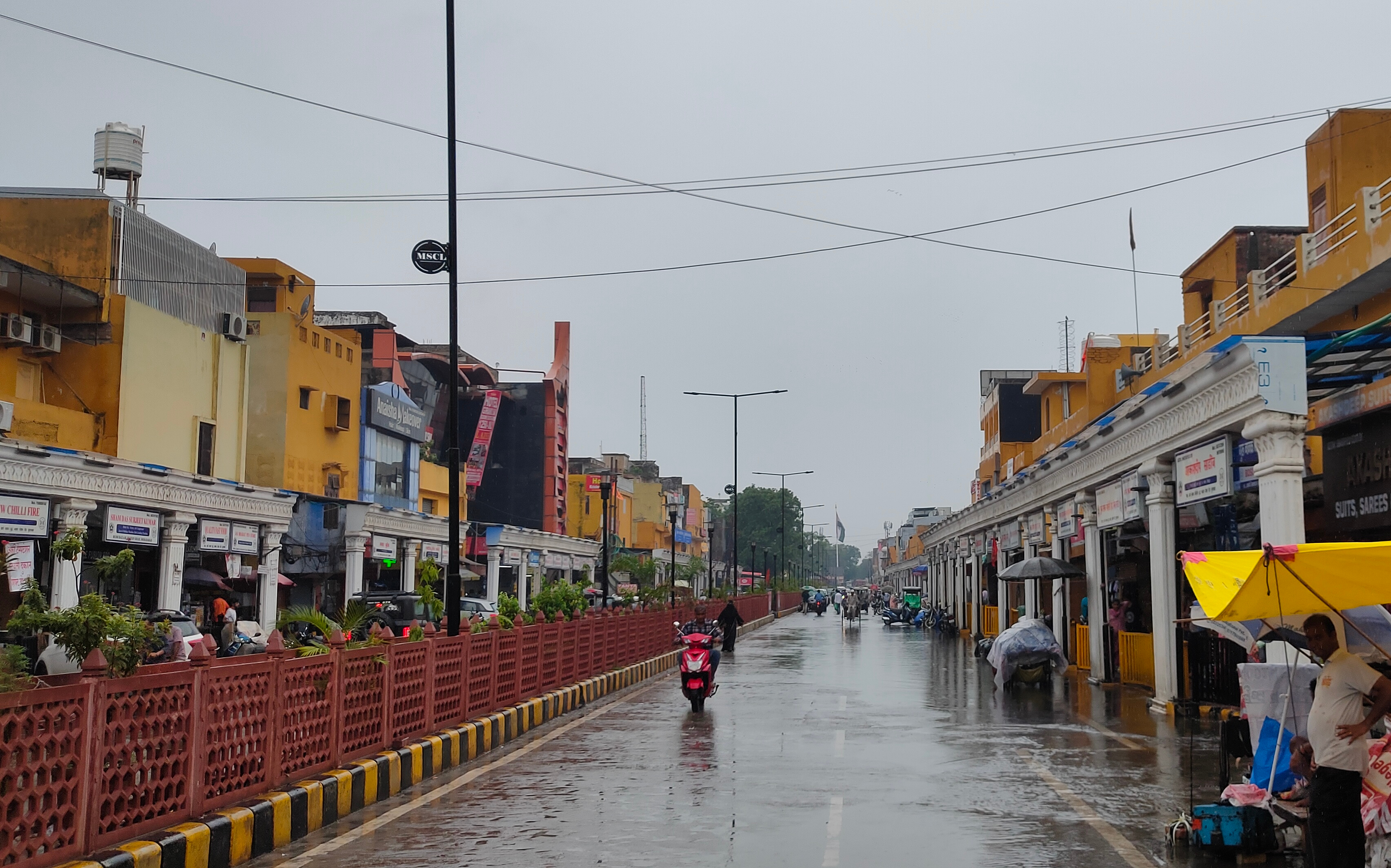 शुक्रवार को बारिश होने के बाद मुरादाबाद के बुध बाजार में गुजरते लोग शुक्रवार को बारिश होने के बाद मुरादाबाद के बुध बाजार में गुजरते लोग