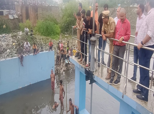 नाले में बहे बच्चे को खोजते गोताखोर नाले में बहे बच्चे को खोजते गोताखोर
