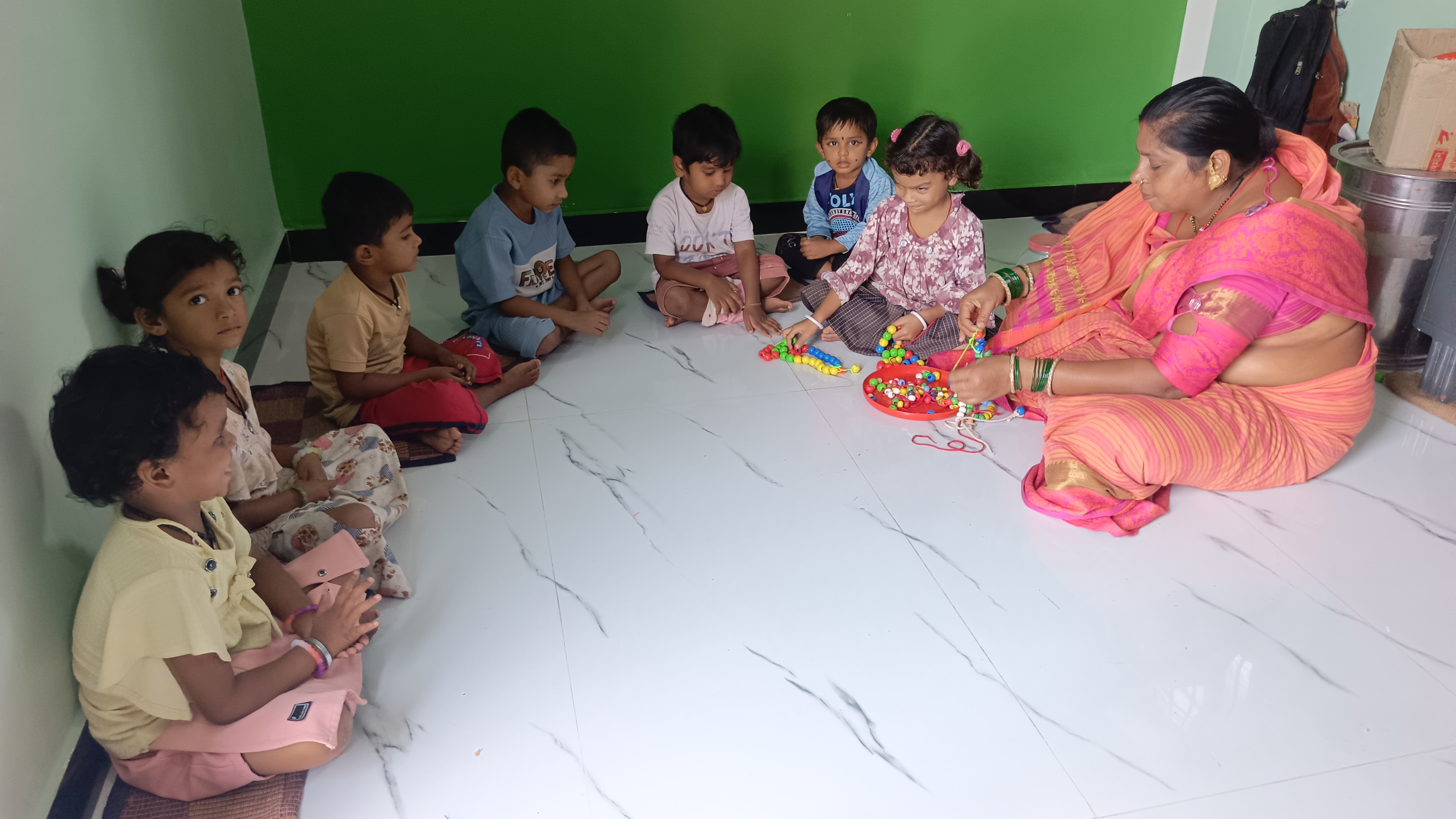 किराये के भवन में बच्चों को खिलाती हुई गोकुलपुर वार्ड आंगनबाड़ी की सहायिका।