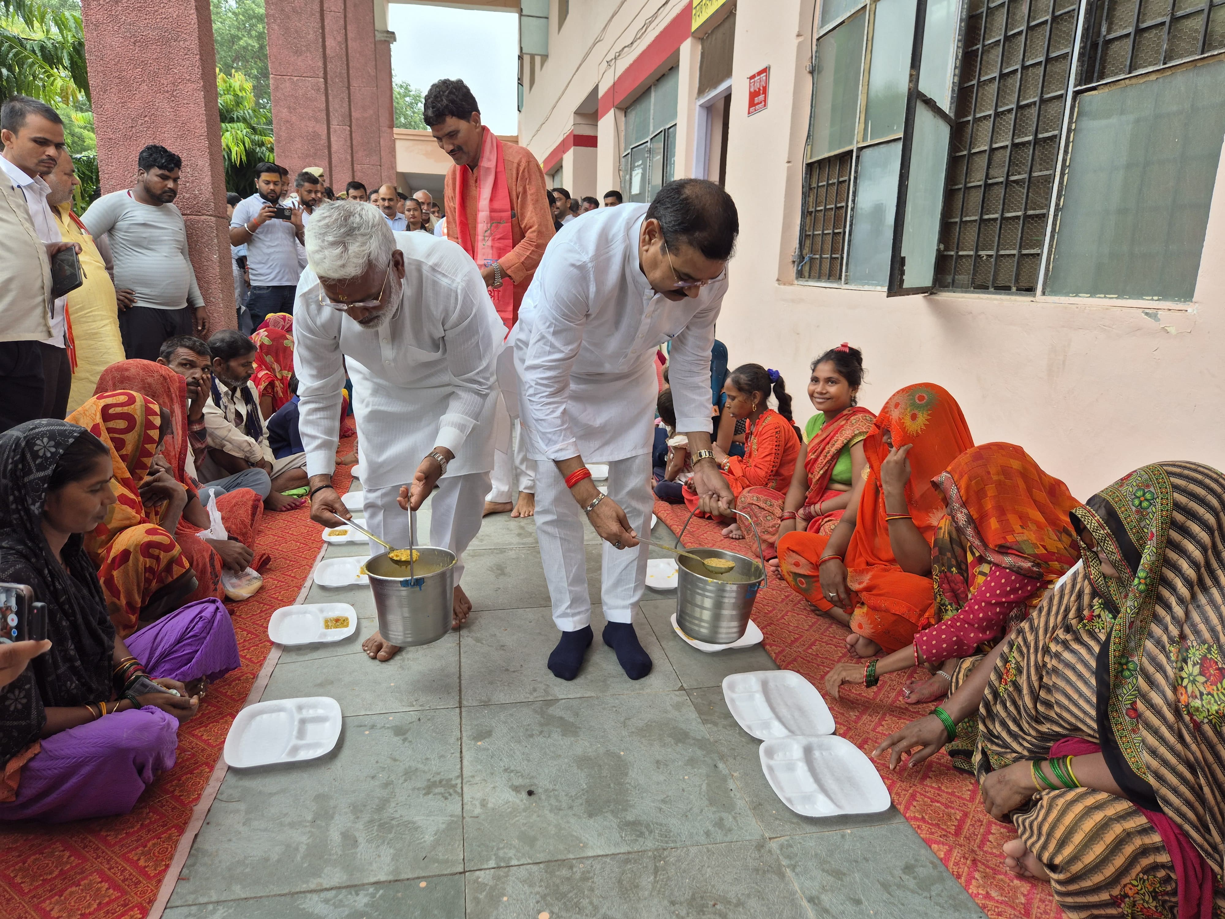 पीड़ितों को भोजन परोसते मंत्री पीड़ितों को भोजन परोसते मंत्री