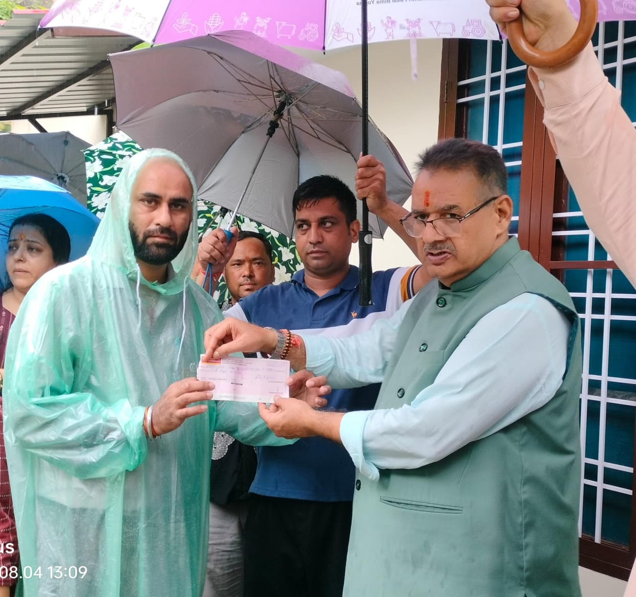 कैबिनेट मंत्री गणेश जोशी  पीड़ितों को राहत राशि के चेक वितरित करते।