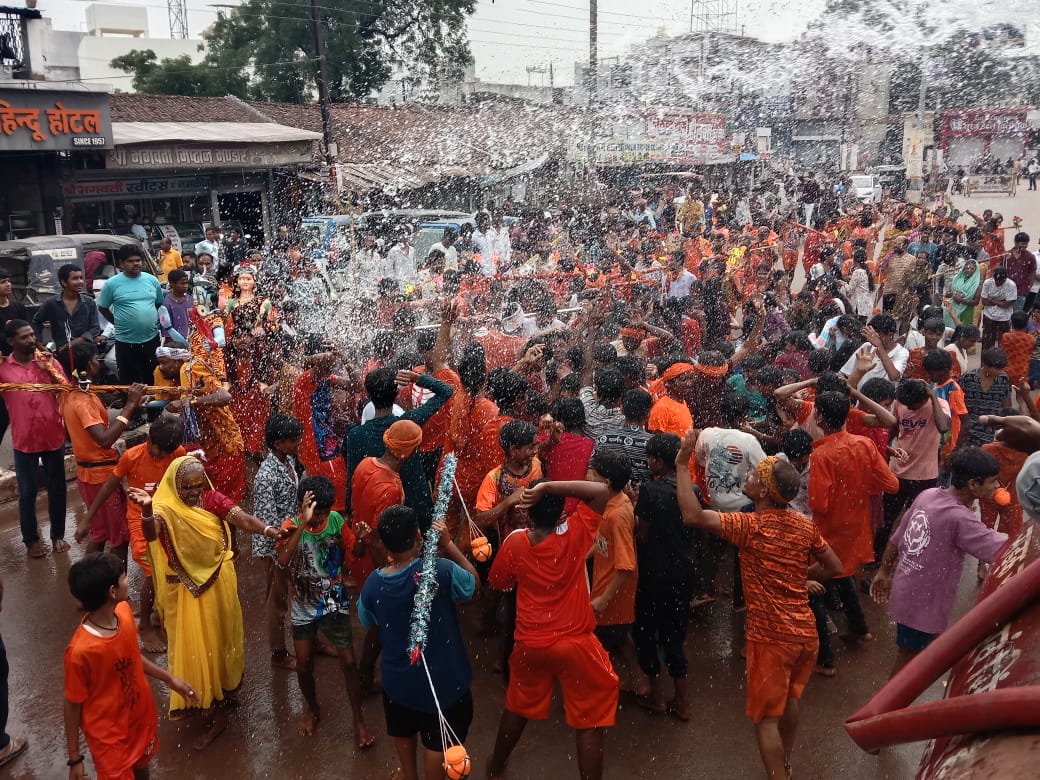पुराना बस स्टैंड के पास कृत्रिम वर्षा में झूमते हुए श्रध्दालु। पुराना बस स्टैंड के पास कृत्रिम वर्षा में झूमते हुए श्रध्दालु।