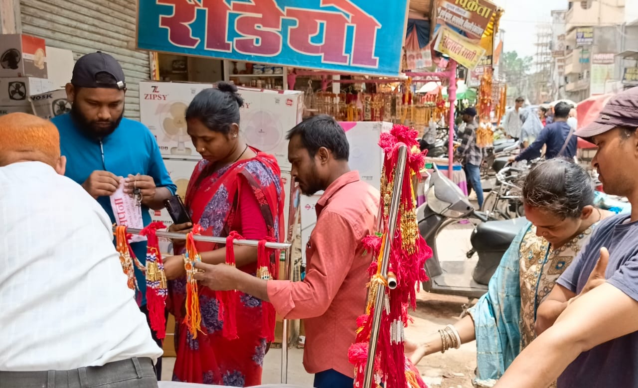 बाजार में राखी पसंद करती हुई बहने। बाजार में राखी पसंद करती हुई बहने।