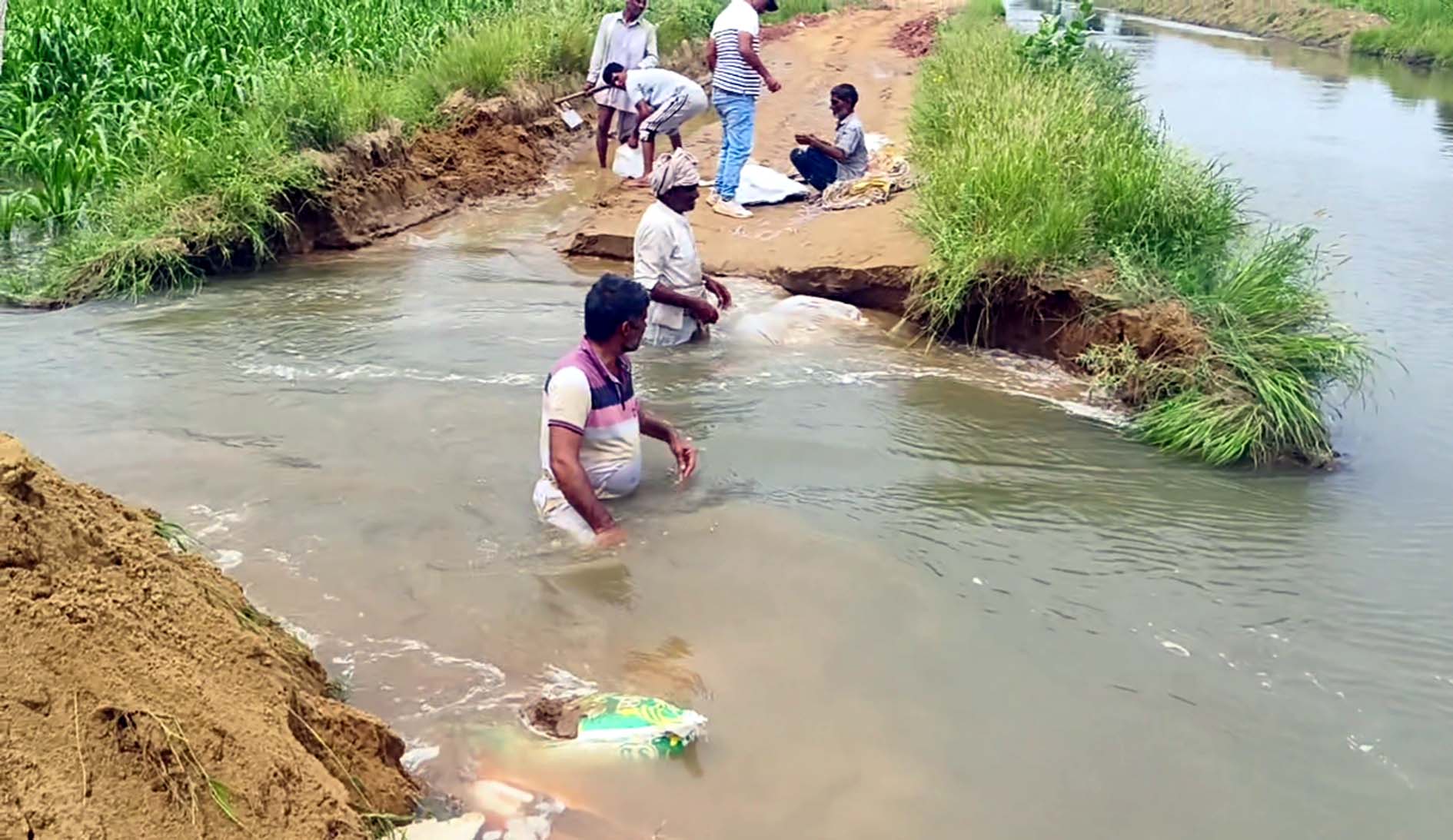 ड्रेन के पानी के बहाव को रोकने का प्रयास करते सिंचाई विभाग के कर्मचारी।