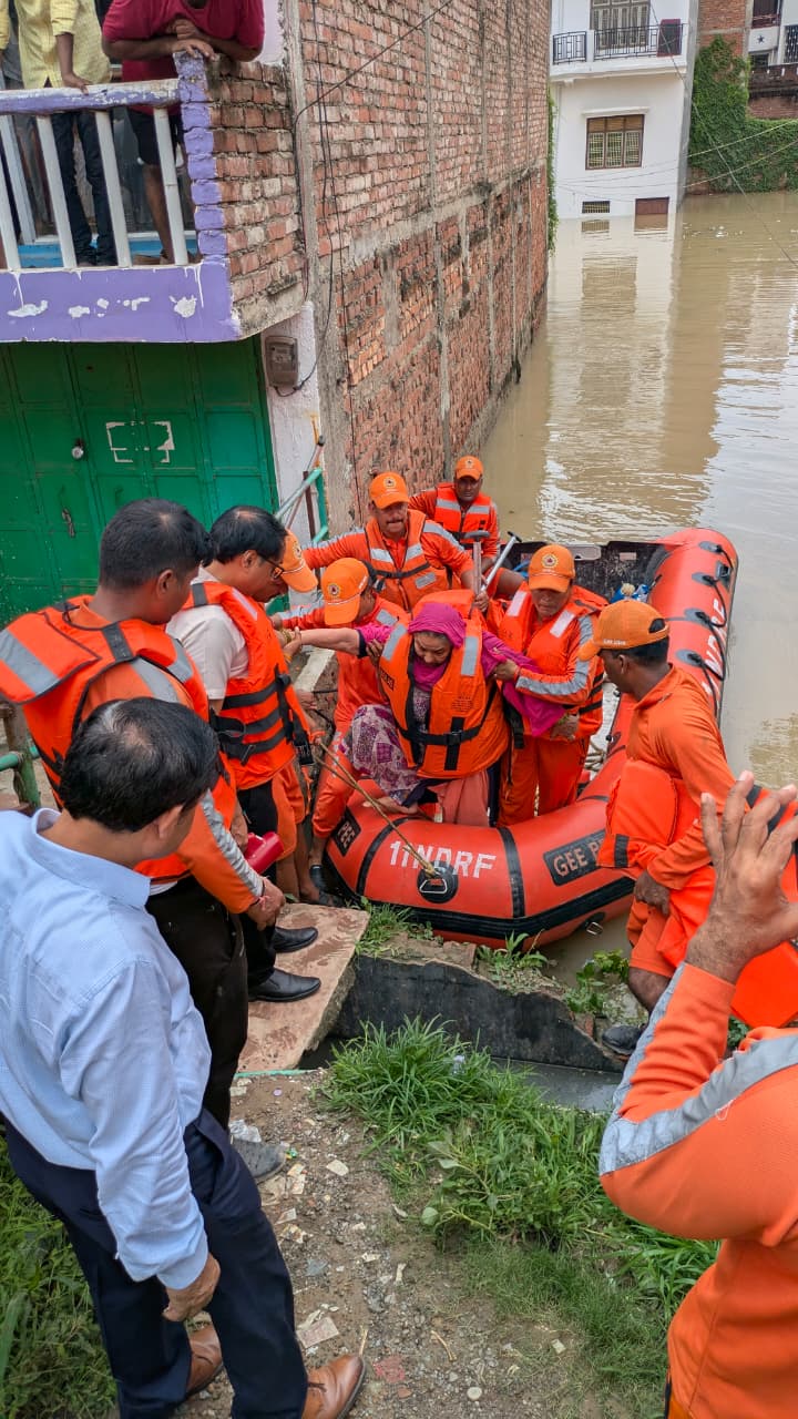 बाढ़ में फंसे लोगों को निकालते एनडीआरएफ के जवान