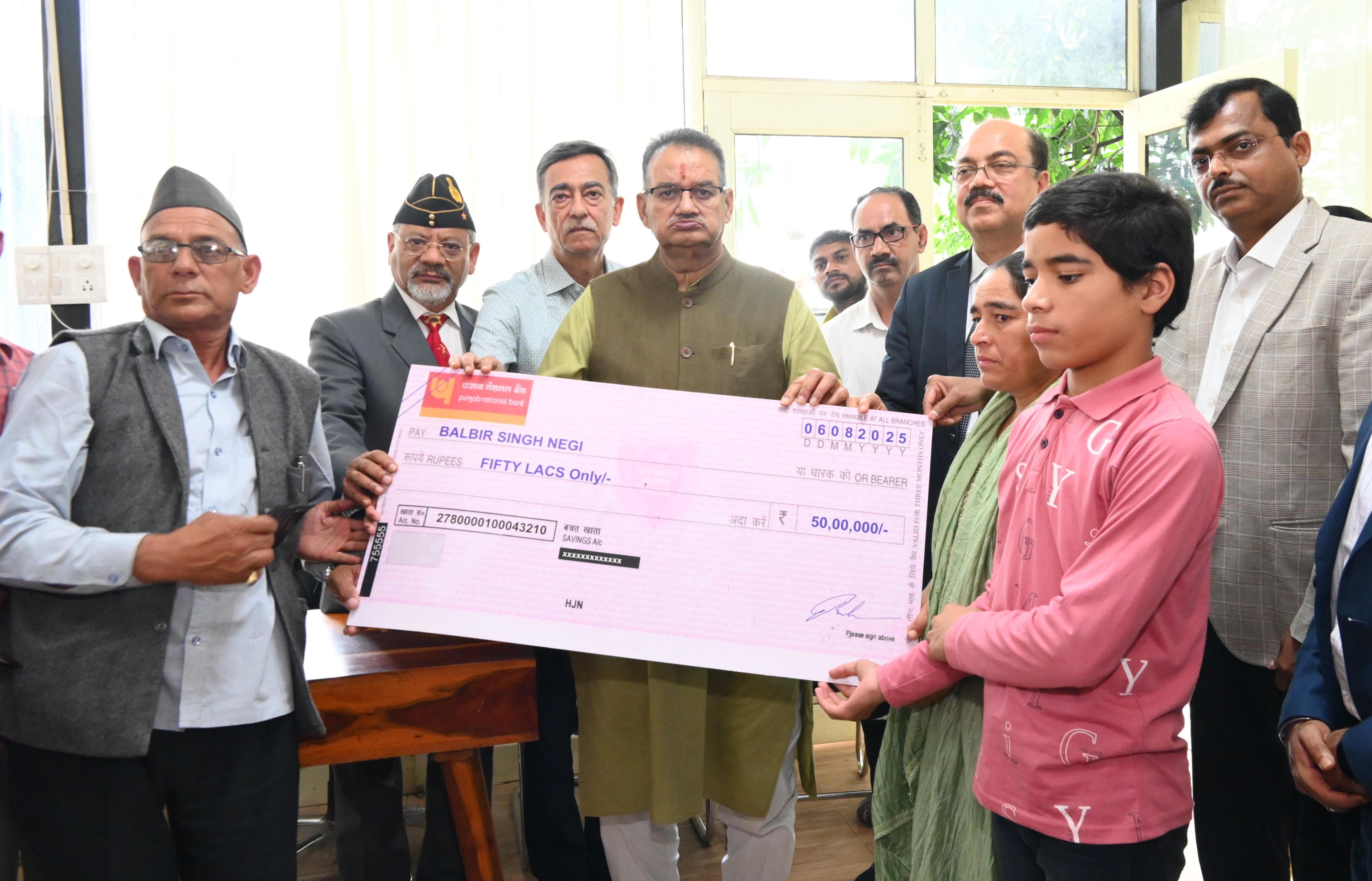 मृतक उपनलकार्मिक के पिता बलवीर सिंह नेगी को चेक सौंपते सैनिक कल्याण मंत्री गणेश जोशी।* मृतक उपनलकार्मिक के पिता बलवीर सिंह नेगी को चेक सौंपते सैनिक कल्याण मंत्री गणेश जोशी।*