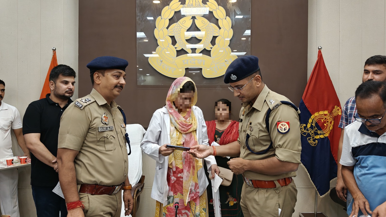 पुलिस अधीक्षक मौबाइल सौंपते हुए
