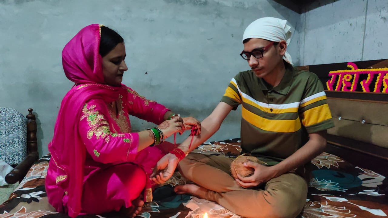 भाई को राखी बांधते हुए बहन।