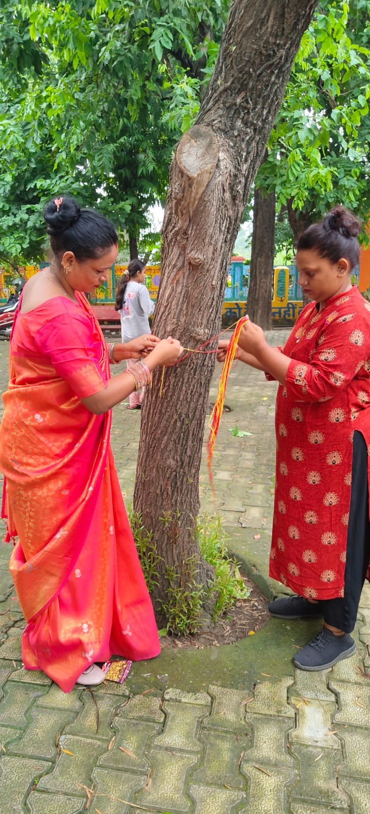 वृक्षों पर रक्षासूत्र बांधकर पेड़ों की रक्षा व सुरक्षा का संकल्प लेते प्रकृति सेवा समिति के पदाधिकारी।