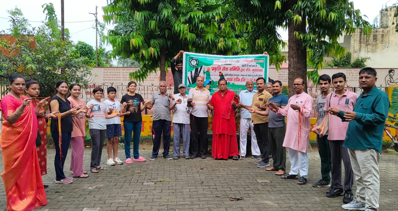 वृक्षों पर रक्षासूत्र बांधकर पेड़ों की रक्षा व सुरक्षा का संकल्प लेते प्रकृति सेवा समिति के पदाधिकारी।