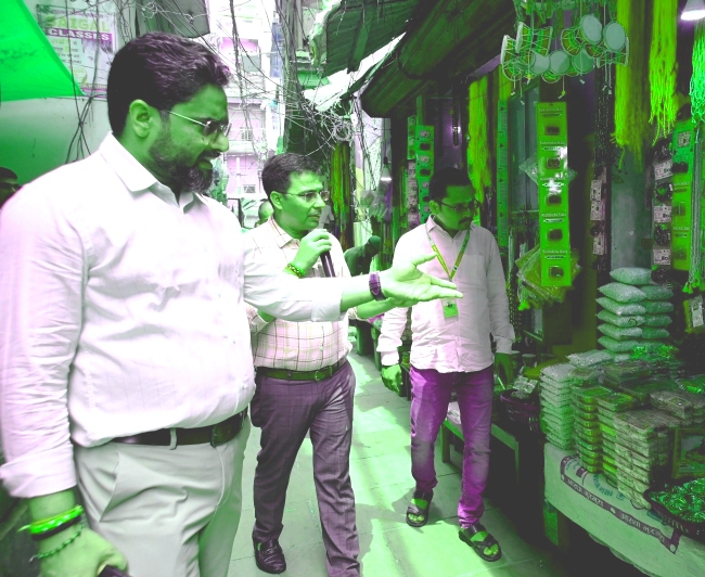 मंदिर की गलियों में दुकानदारों से वार्ता करते न्यास अधिकारी (फोटो)