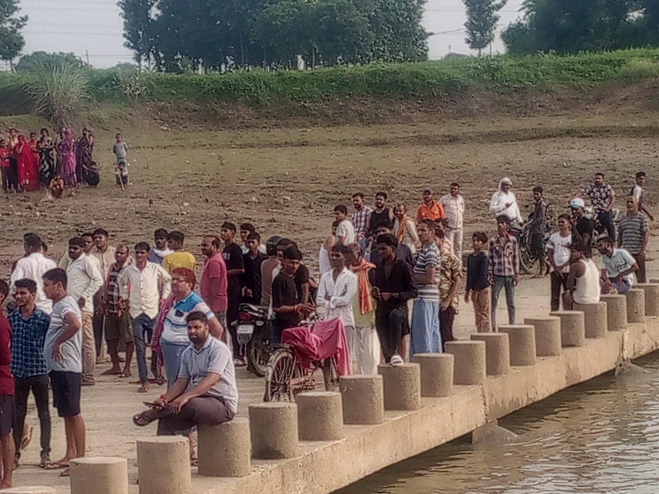 डेरवां बलापुर गाँव में कर्णावती नदी में छात्र के डूबने के बाद मौके पर जुटे ग्रामीण