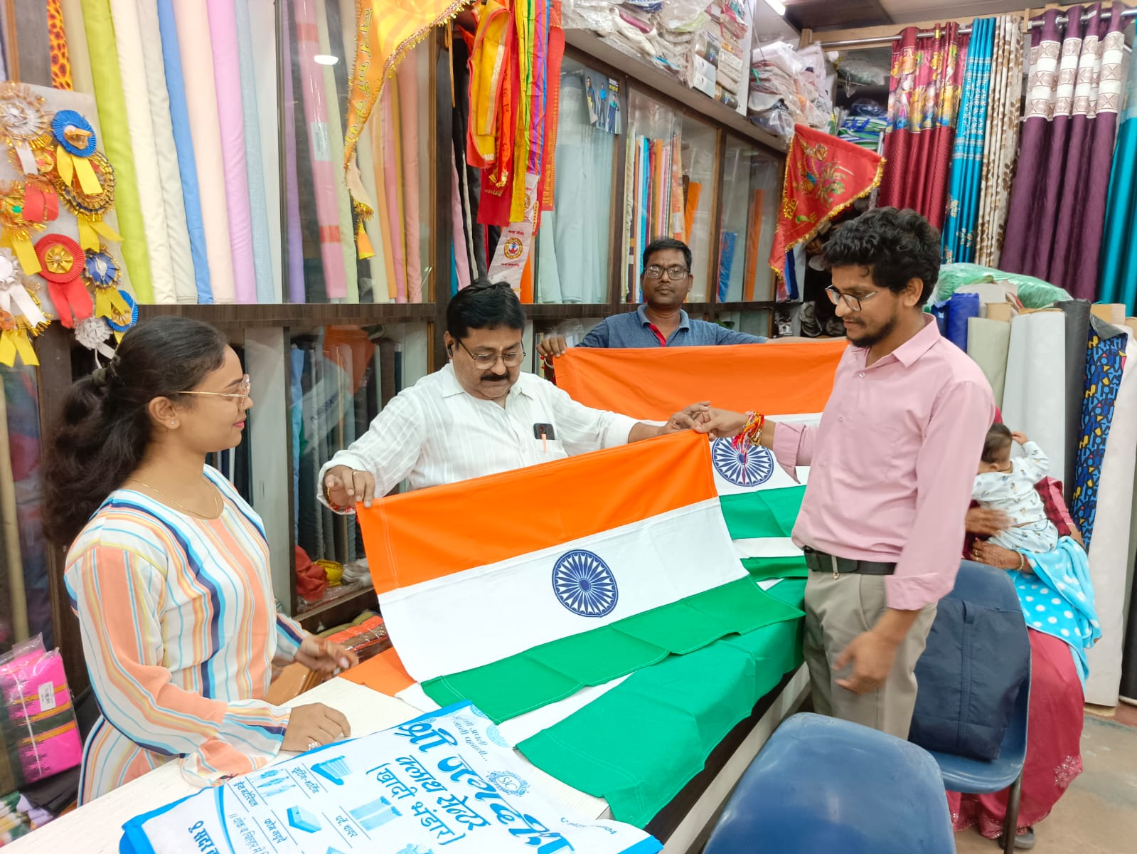 शहर की एक दुकान में तिरंगा झंडा खरीदते हुए लोग।