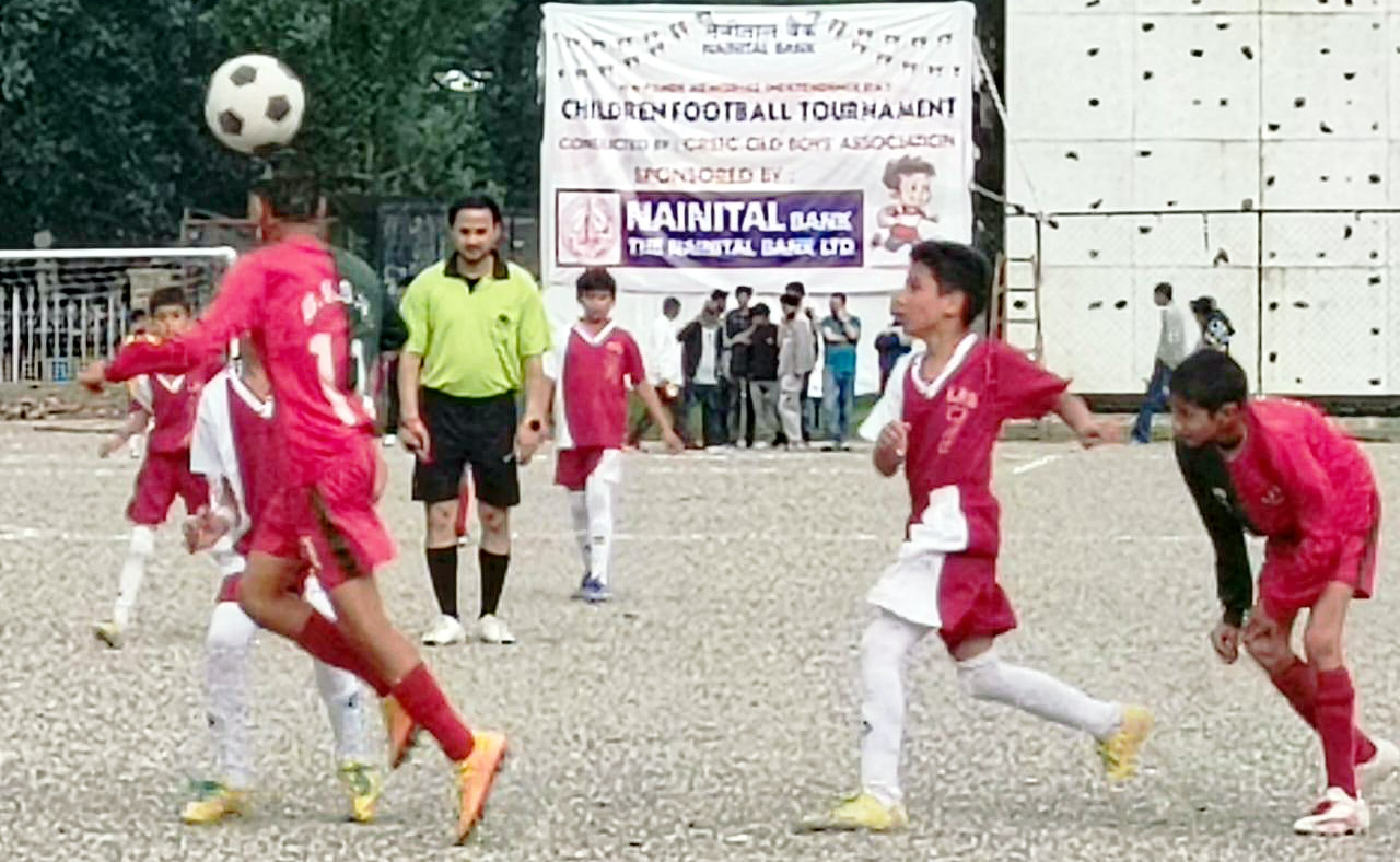 फुटबॉल प्रतियोगिता में गैंद के लिये भिड़ते खिलाड़ी।