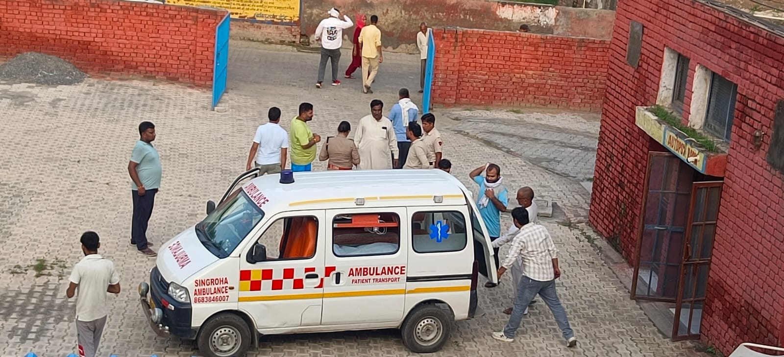 नागरिक अस्पताल में मृतक के शव का पोस्टमार्टम करवा ले जाते हुए परिजन।