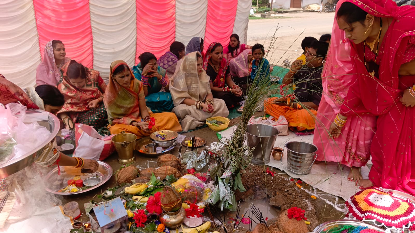 समूह में पूजा अर्चना करती हुई महिलाएं।