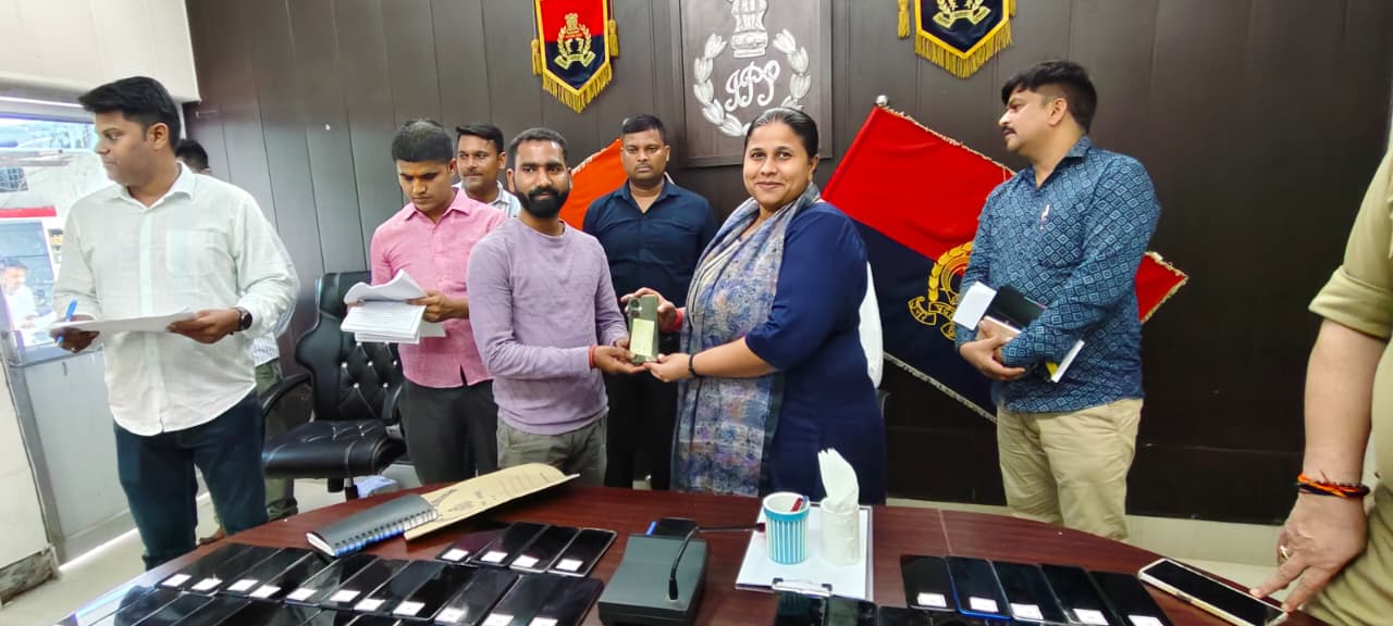 मोबाइल फोन को उनके मालिक को सुपुर्द करती हुई एसपी