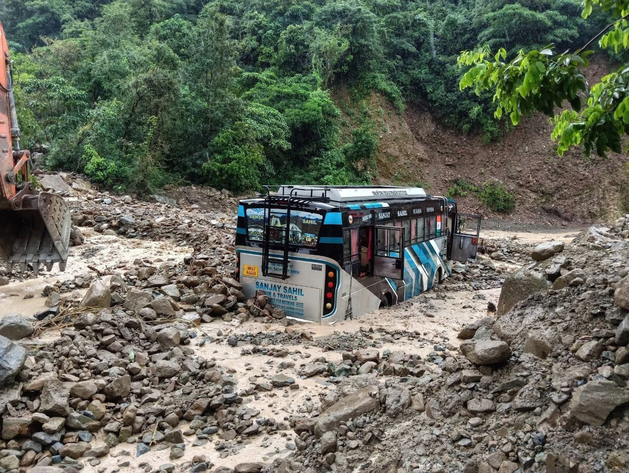मलबे में फंसी निजी बस मलबे में फंसी निजी बस