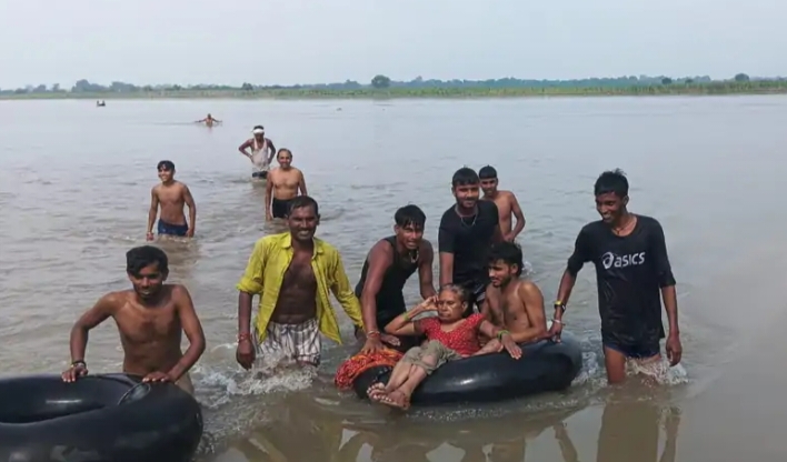 महिला को यमुना से निकालते ग्रामीण