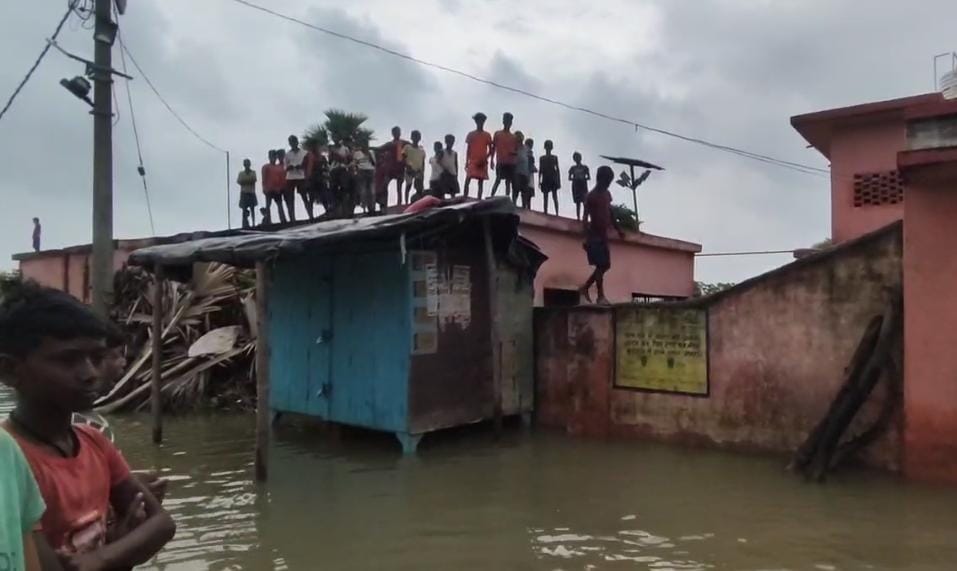 छत पर मौजूद बाढ़ पीड़ित