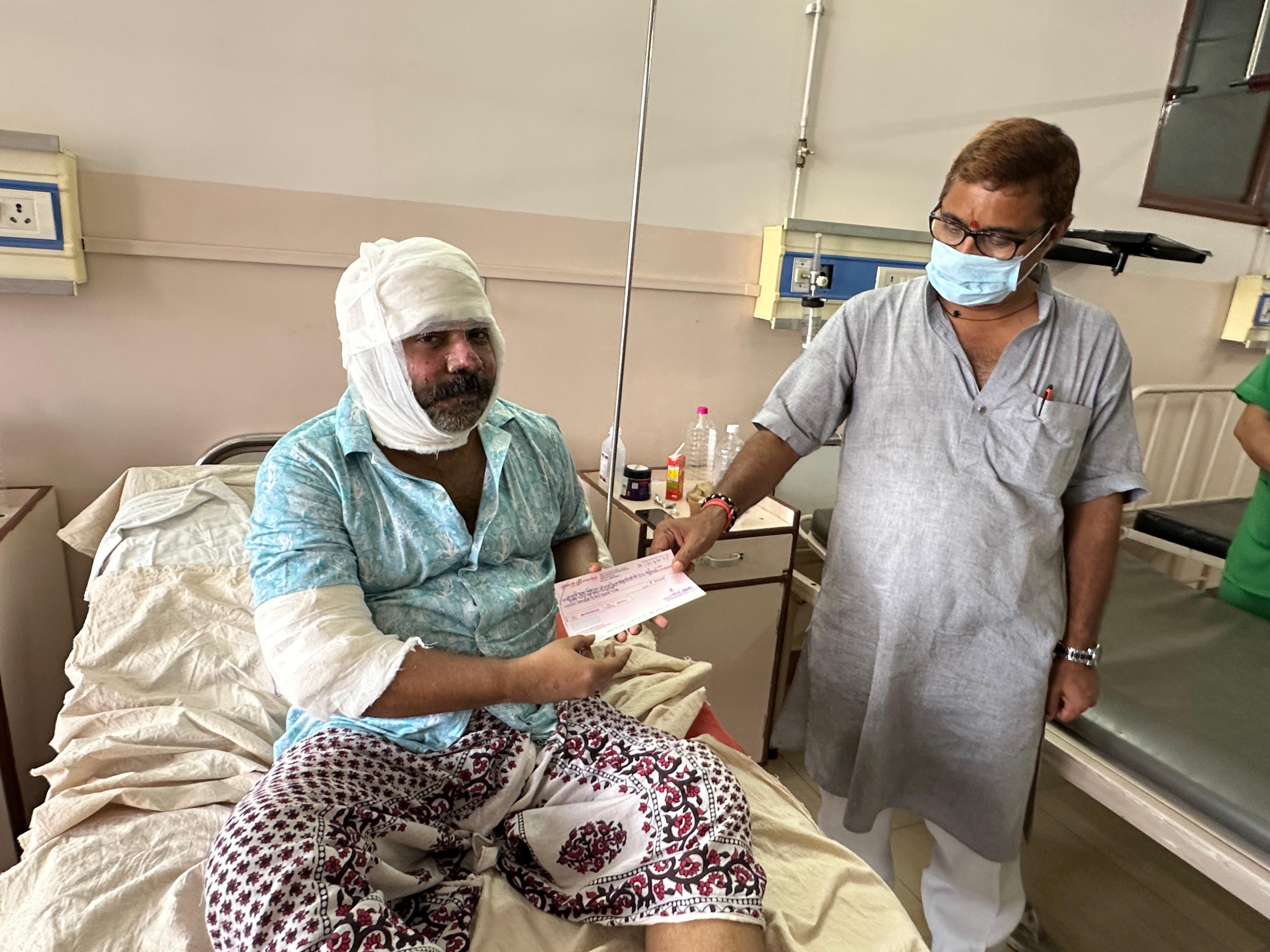 झुलसे लोगों को  आर्थिक सहायता राशि का चेक देते विधायक नीलकंठ