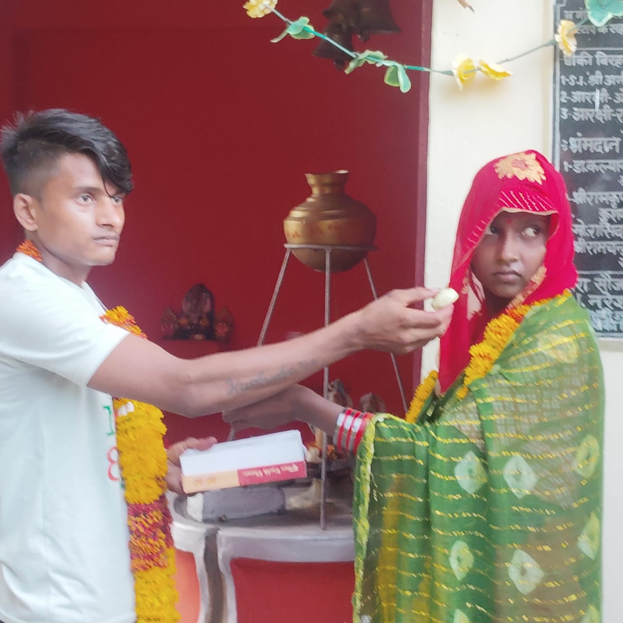 एक दूसरे को वरमाला पहनाते  प्रेमी युगल