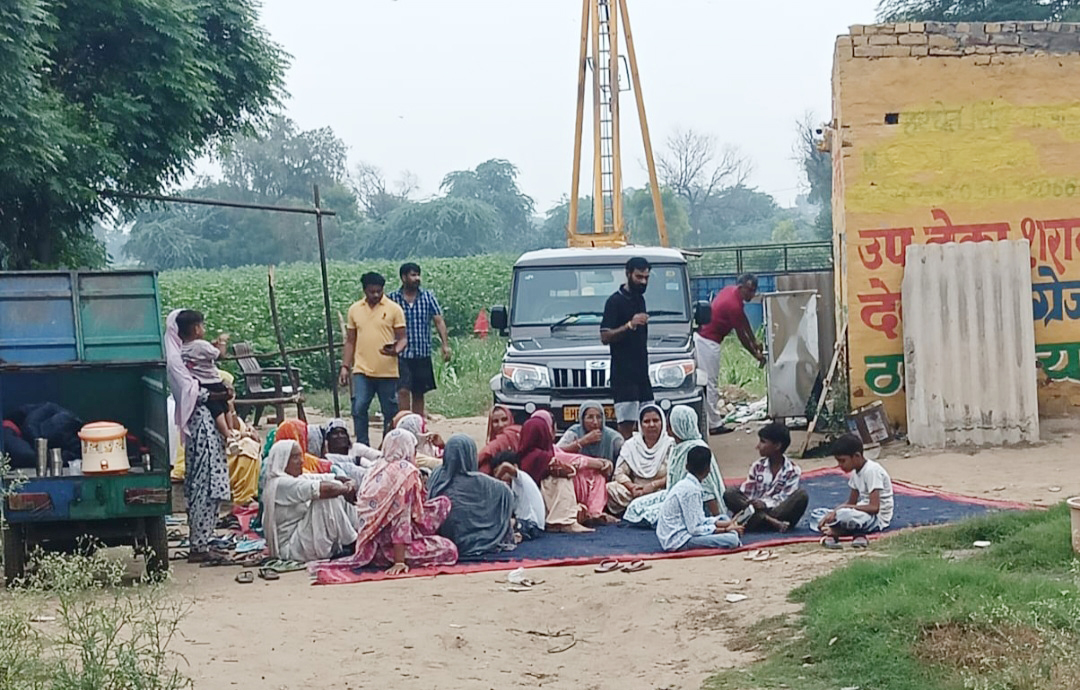 शराब ठेके पर ताला लगाने के बाद धरने पर बैठी महिलाएं।