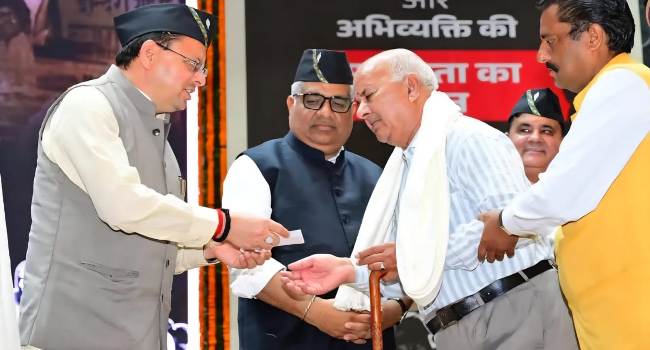 एक कार्यक्रम में लाेकतंत्र सेनानी काे सम्मानित करते मुख्यमंत्री धामी।