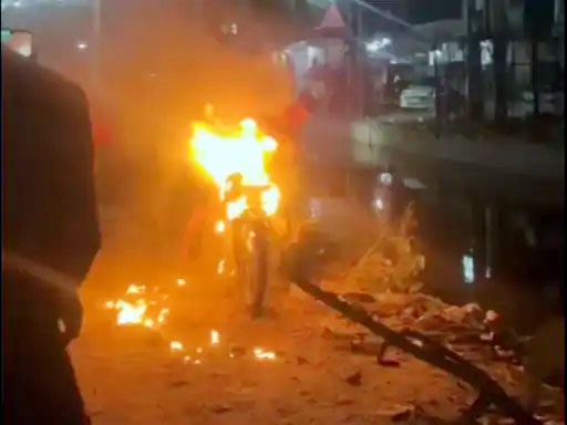 जलती बाइक का दृश्य।
