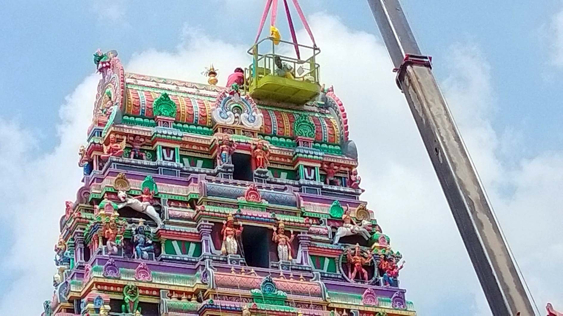 तिरुपति धाम में गोपुरम पर कलश स्थापित करते अर्चक।