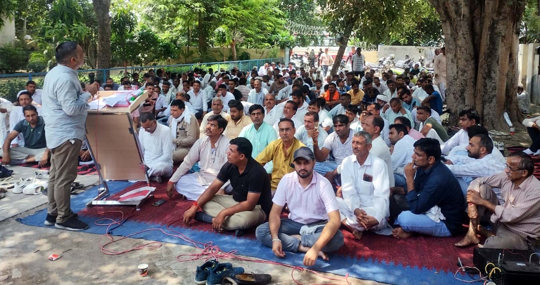 प्रदर्शनकारी कर्मचारियों को संबोधित करते यूनियन पदाधिकारी।
