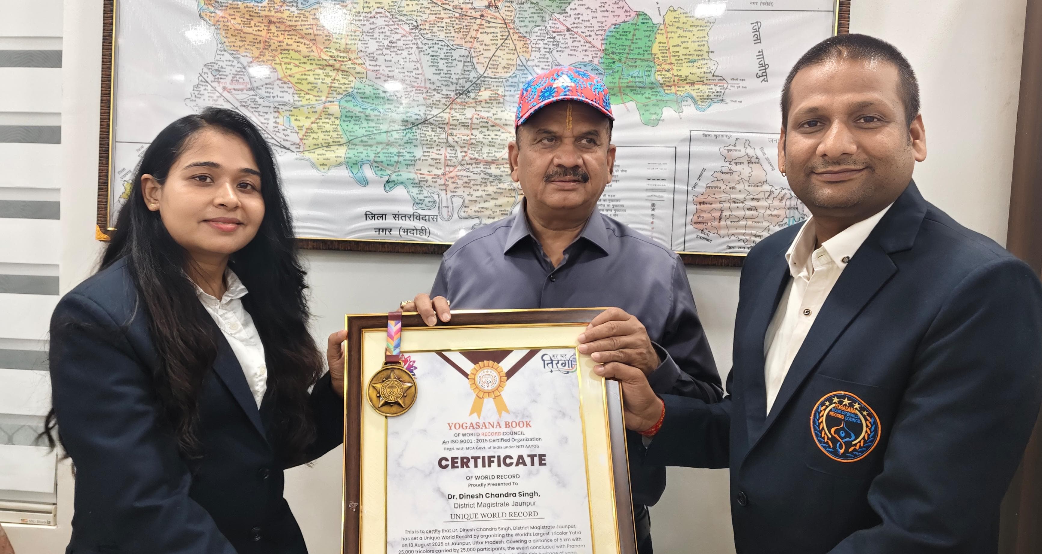 जिलाधिकारी को सम्मानित करते हुए योगासन बुक ऑफ वर्ल्ड रिकॉर्ड