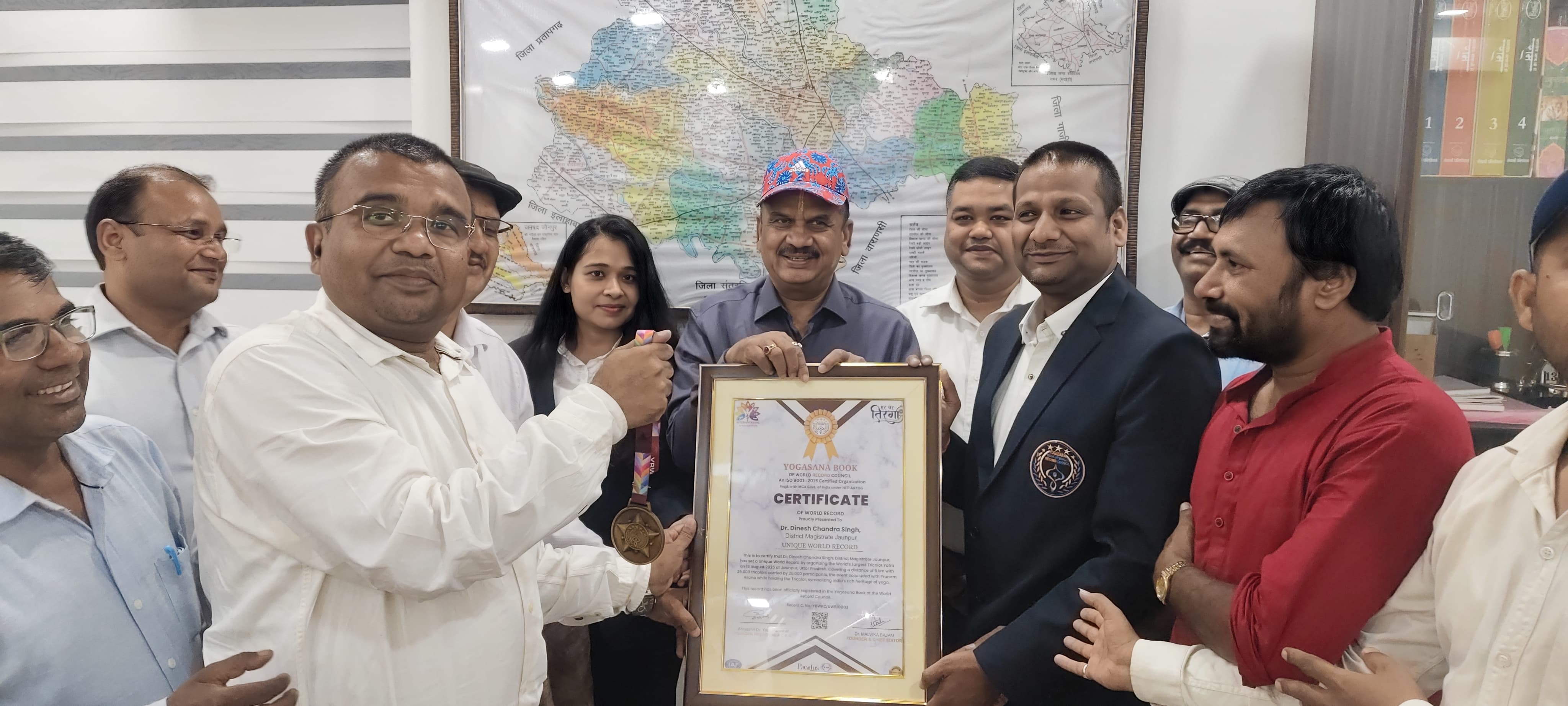 योगासन बुक ऑफ वर्ल्ड रिकॉर्ड लेते हुए डीएम और बीएसए