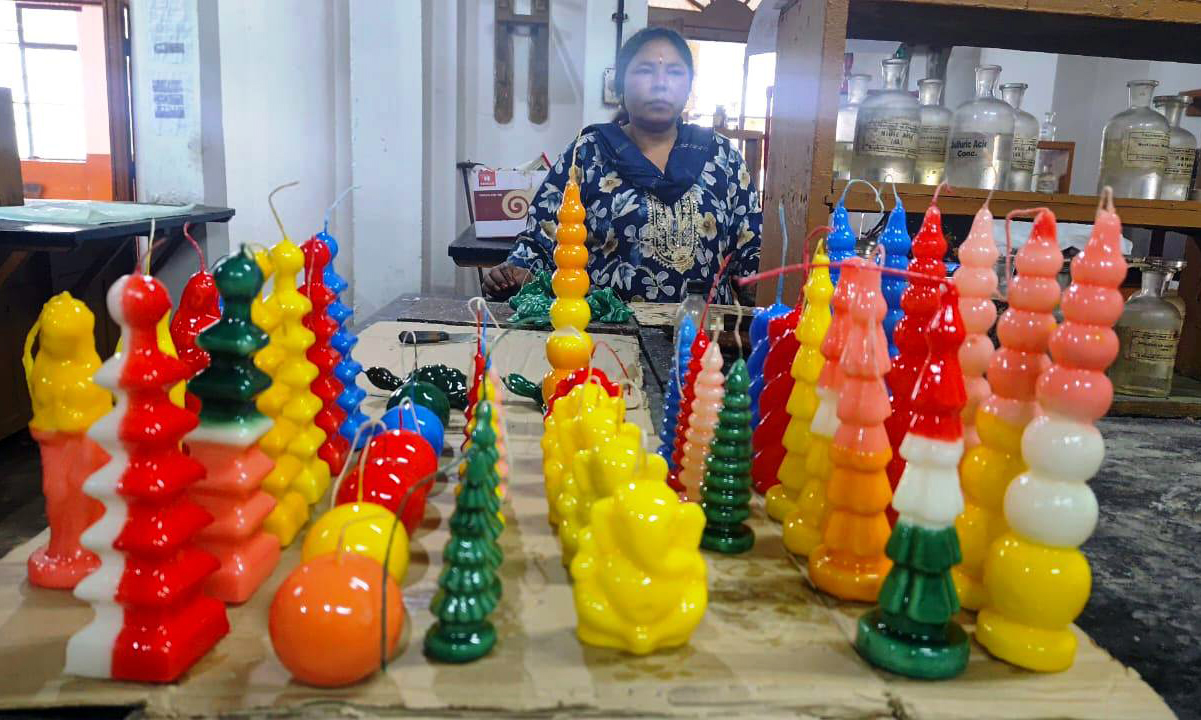 कार्यशाला में तैयार मोमबत्तियों के साथ विशेषज्ञ।
