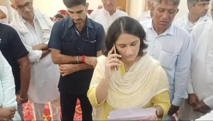 मोबाइल पर थाना प्रभारी से बात करते हुए विधायक विनेश फोगाट।