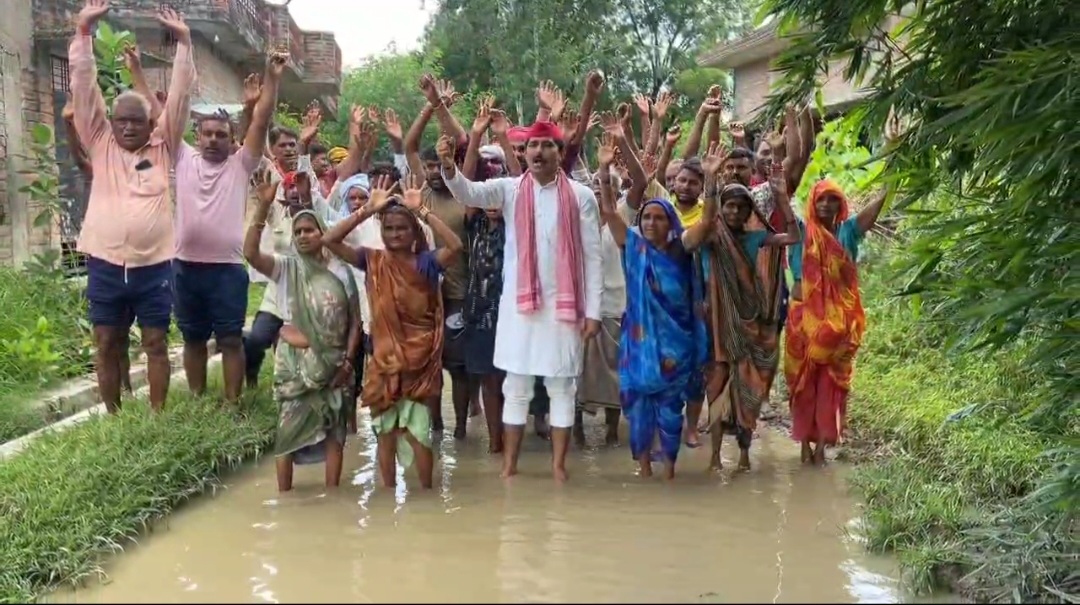 पानी में घुसकर प्रदर्शन करते हुए ग्रामीण और सपा नेता पानी में घुसकर प्रदर्शन करते हुए ग्रामीण और सपा नेता