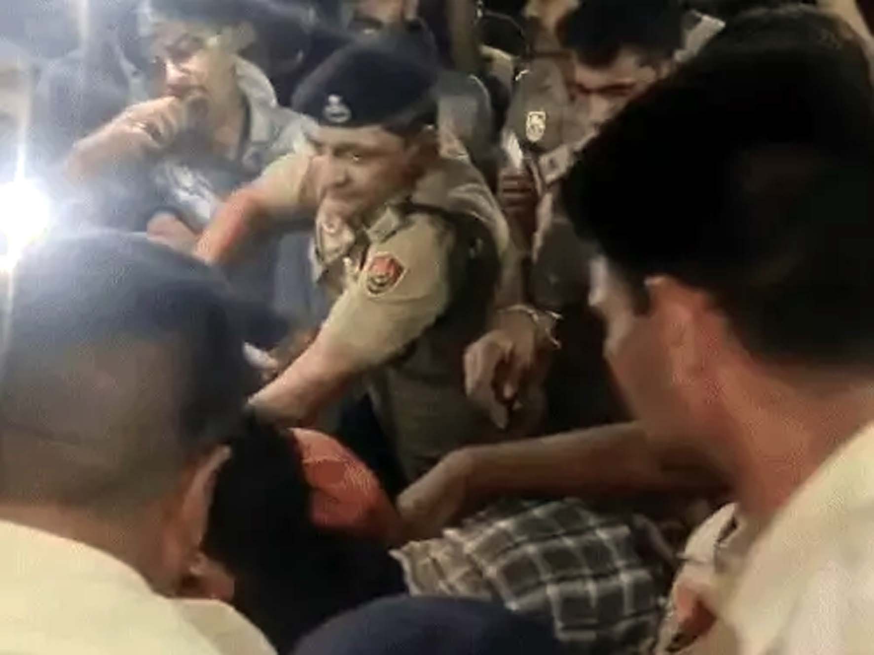 रात को छात्रों को खदेड़ते पुलिस कर्मचारी।