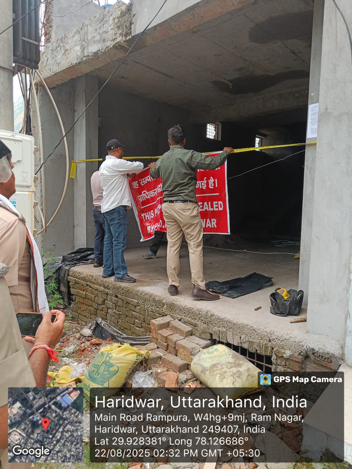 प्राधिकरण द्वारा भवन सील करते हुए प्राधिकरण द्वारा भवन सील करते हुए