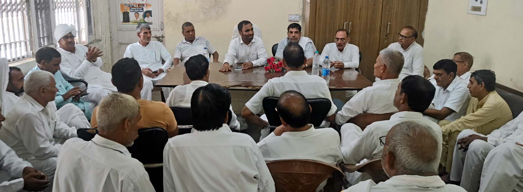 जिला अध्यक्ष बृजलाल से बातचीत करते रिटायर्ड कर्मचारी।