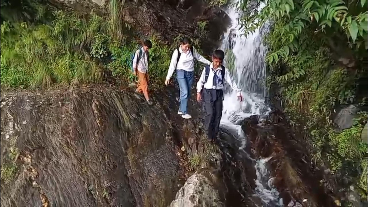 खतरनाक रास्ते से गुजरते हुए बच्चे।