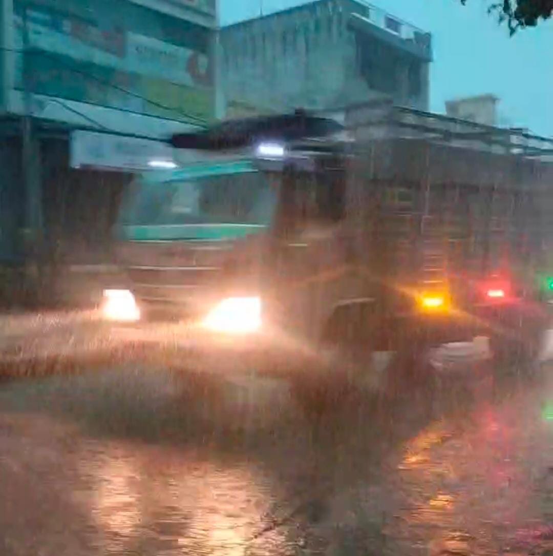 तेज बारिश के बीच लाइट जला कर सड़क से गुजरते वाहन। तेज बारिश के बीच लाइट जला कर सड़क से गुजरते वाहन।